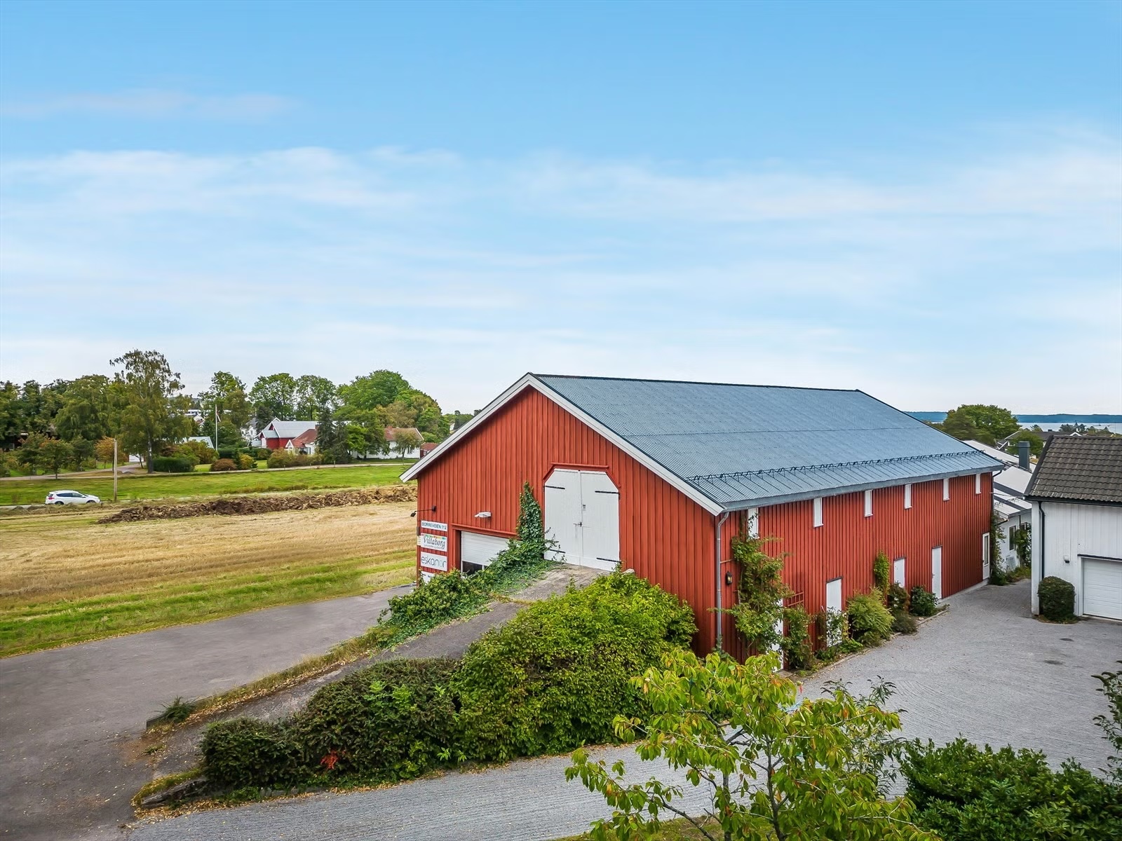 Låven i Horten sett fra tunet, omkranset av bjørketrær
